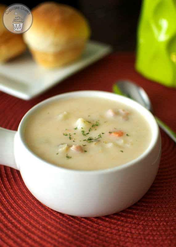 Slow Cooker Ham and Potato Soup in a white bowl with a spoon.