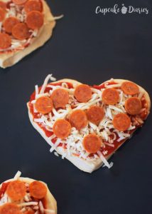 Mini Heart Pizzas - Add pizza sauce, cheese, and toppings to each pizza