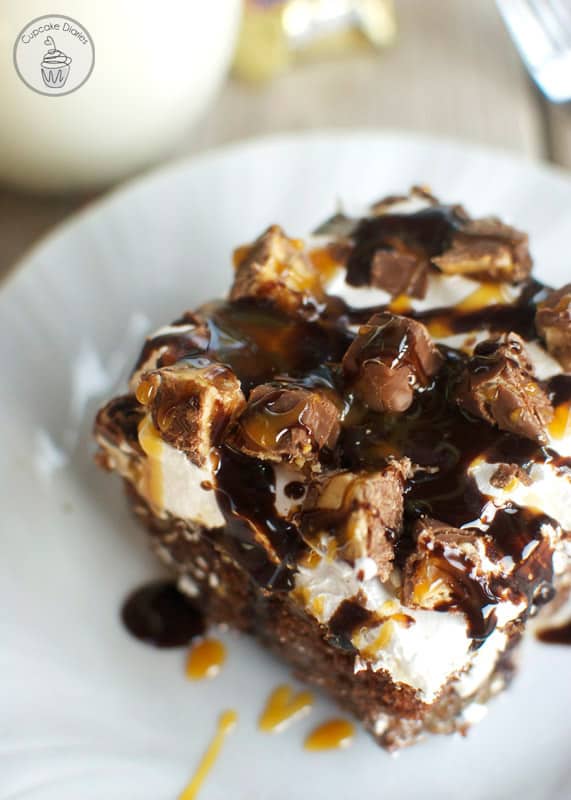 Snickers Poke Cake - This cake is so moist and decadent with chewy Snicker bars on top. This cake is amazing!