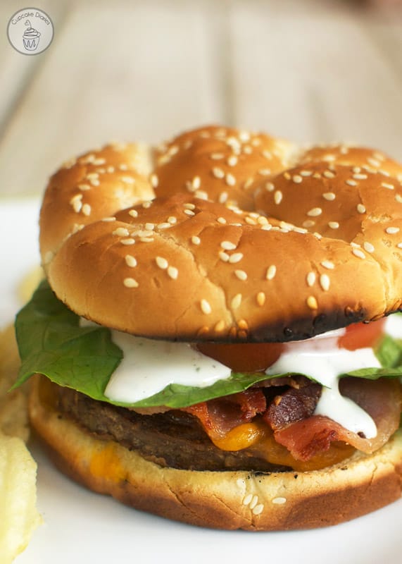 Bacon Ranch Burger - A juicy cheeseburger topped with crispy bacon and a tangy ranch dressing. Perfect for a summer BBQ!