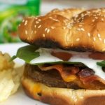 Bacon Ranch Burger - A juicy cheeseburger topped with crispy bacon and a tangy ranch dressing. Perfect for a summer BBQ!