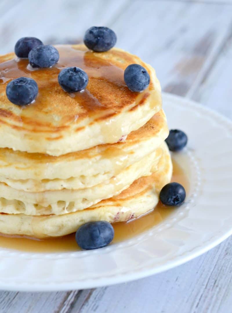 A stack of pancakes topped with blueberries. 