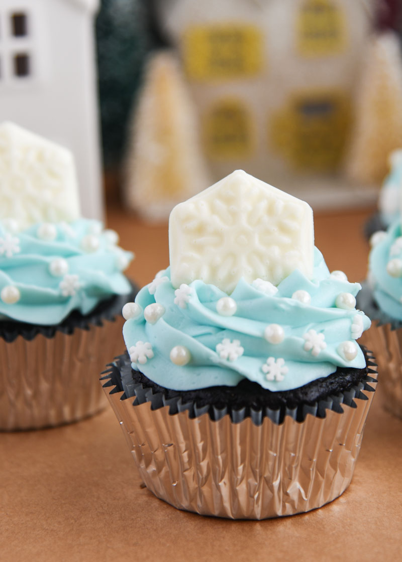 Snowflake Cupcakes for a Frozen themed party or wintertime treat! Each cupcake is topped with winter sprinkles and a solid white chocolate snowflake.